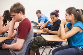 Students focusing on mobile phones in classroom