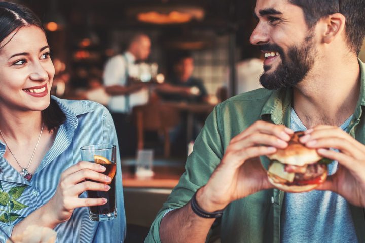 a couple eating hamburgers in a restaurant