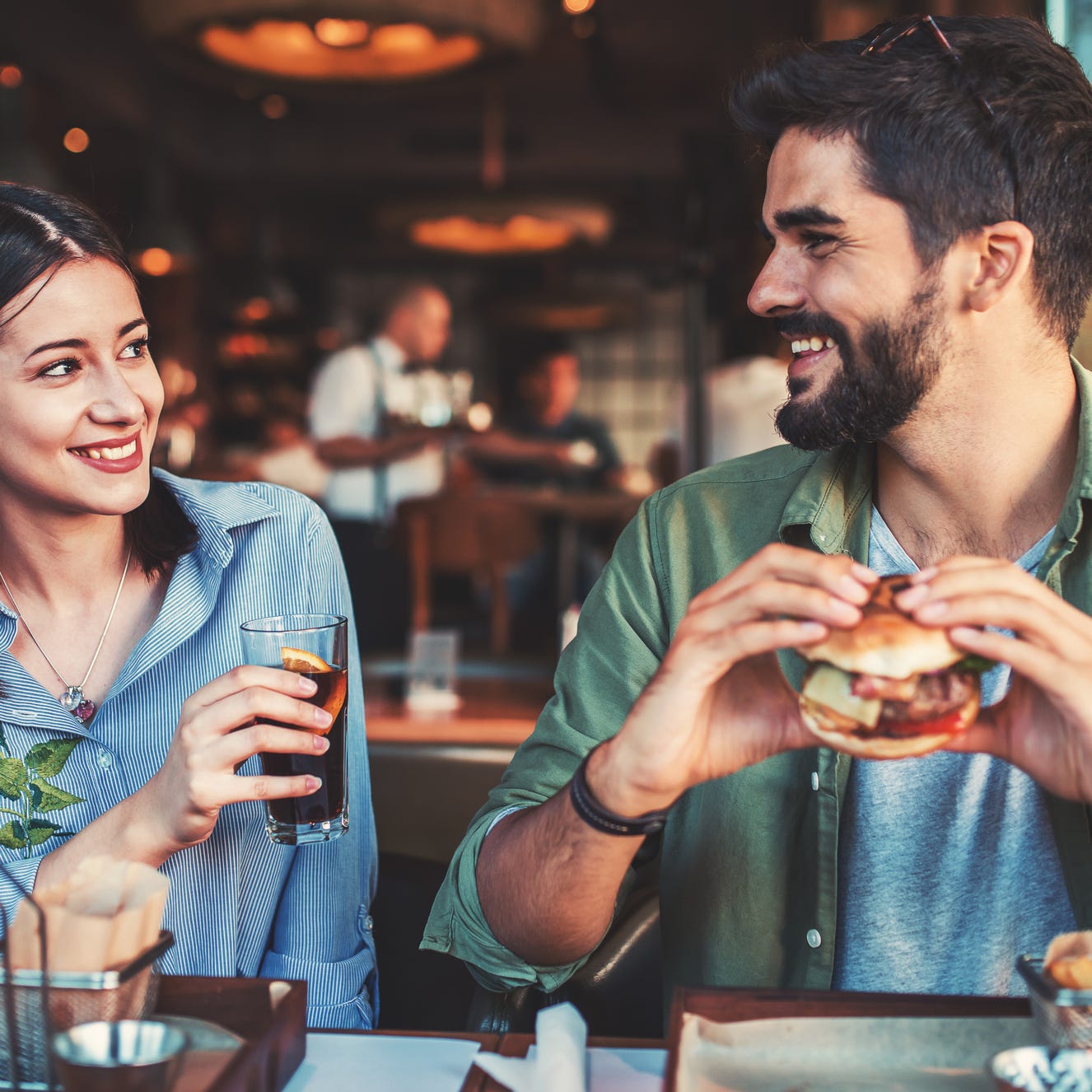 a couple eating hamburgers in a restaurant