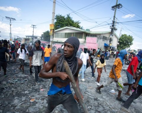 FILE - A protester carries a piece of wood simulating a weapon during a protest demanding the resignation of Prime Minister Ariel Henry, in the Petion-Ville area of Port-au-Prince, Haiti, Oct. 3, 2022.