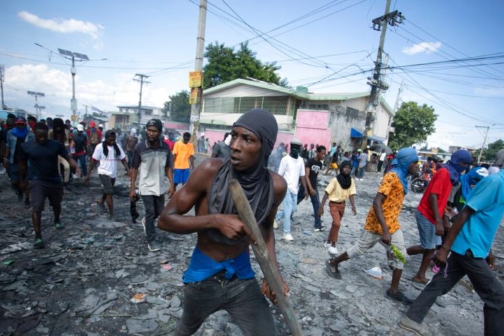 FILE - A protester carries a piece of wood simulating a weapon during a protest demanding the resignation of Prime Minister Ariel Henry, in the Petion-Ville area of Port-au-Prince, Haiti, Oct. 3, 2022.