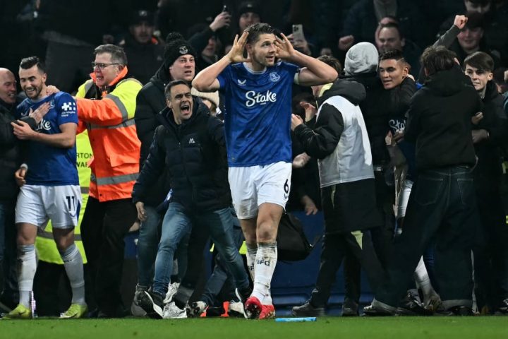 Everton captain James Tarkowski is mobbed by fans as he celebrates scoring the equaliser against Liverpool