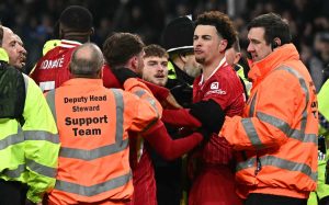 Liverpool's Curtis Jones is held back by stewards to avoid free for all brawl